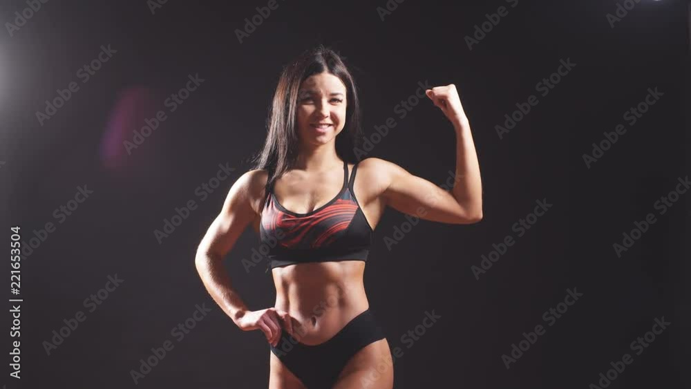 Portrait of young fitness woman shows biceps Portrait of young fitness woman shows biceps