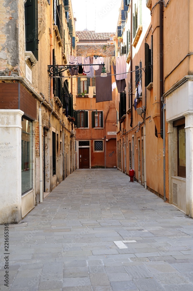 Stradina nella città di Venezia con antiche case tradizionali e biancheria stesa ad asciugare al sole