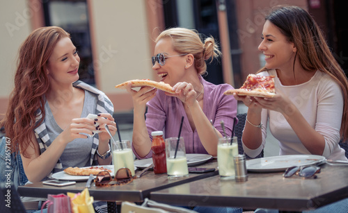 Friends eating pizza in cafe