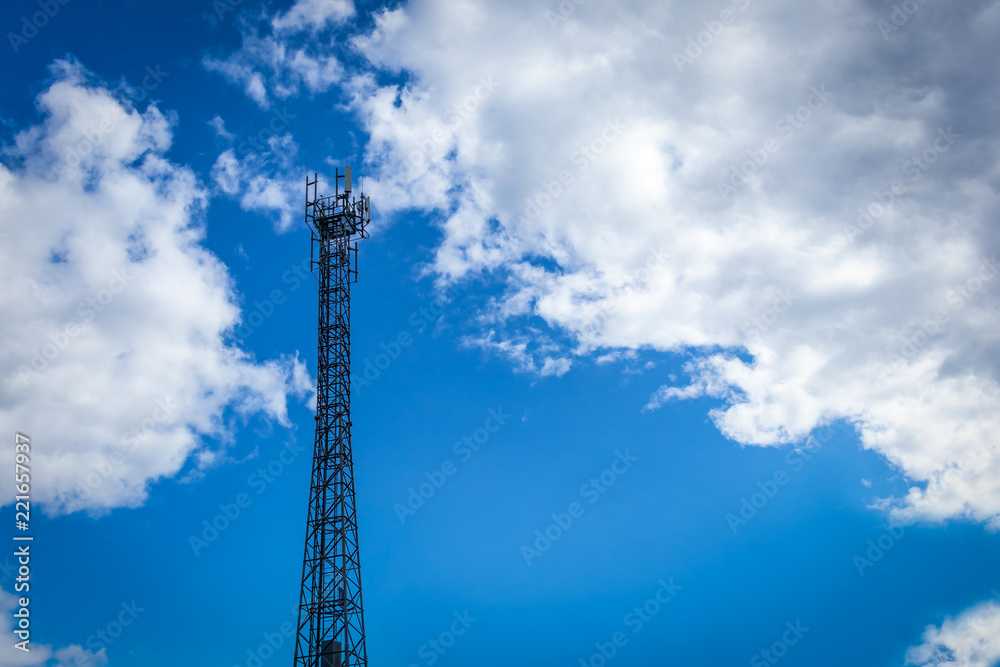 Steel tower with cellular transmitters against a blue sky with clouds Steel tower with cellular transmitters against a blue sky with clouds