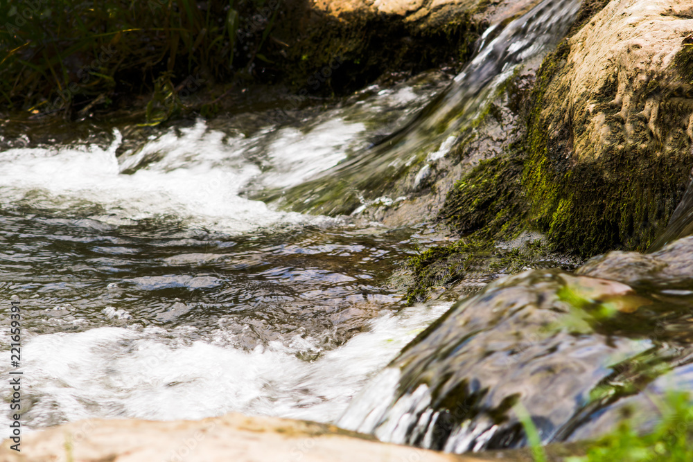 a stormy stream of water flows between the rocks a stormy stream of water flows between the rocks