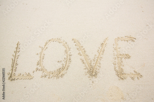 writing love on sand. love message written in sand © kanpisut