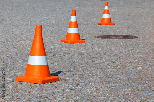 Traffic cone on the street paved with granite cobblestones