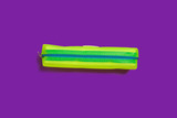 bright closed yellow pencil case lying on a purple background. free space for advertising text. concept of school supplies