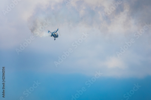 Gyrocopter or autogyro in flight in the blue sky at Air Show Mazury 2018 event at the lake Niegocin in Gizycko. Poland.