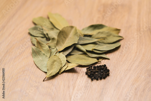 Fototapeta Naklejka Na Ścianę i Meble -  Dry bay leaves with pepper on oak wood table