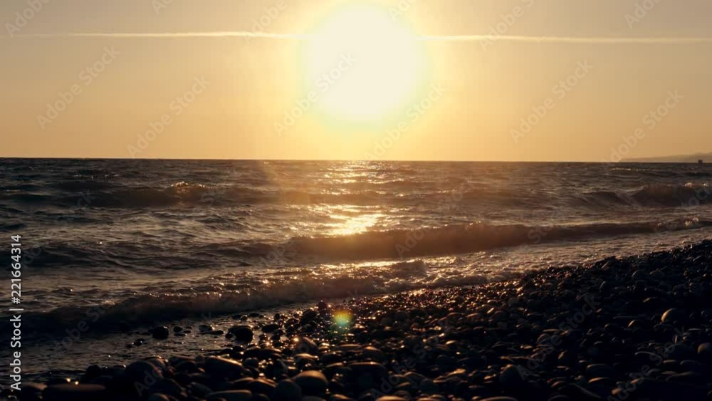 Big waves on a sea beach at sunset. Beautiful waves of slow motion video on the background of the orange sun Big waves on a sea beach at sunset. Beautiful waves of slow motion video on the background of the orange sun