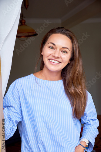 Beauty young woman with white perfect smile looking at camera at home. Happy relax woman alone indoor