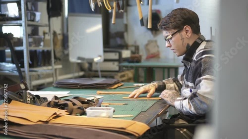 American entrepreneur works with real leather sitting at desk in lighting room, side view of young businessman is in working process with new startup project for retail, worker doing job. Concept