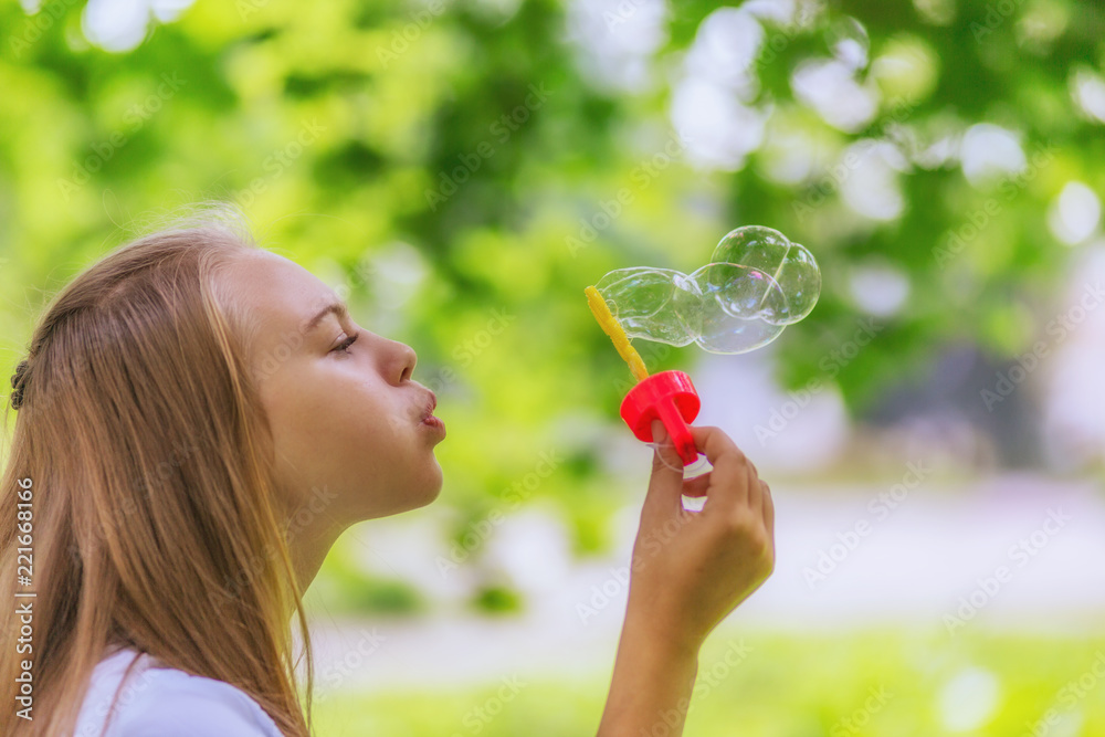 Teen girl blows soap bubbles