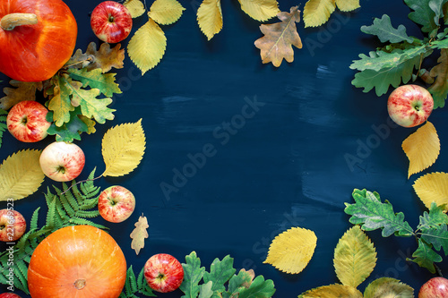 Fototapeta Naklejka Na Ścianę i Meble -  Autumn background from fallen leaves and fruits with vintage place setting on dark wooden table. Thanksgiving day concept