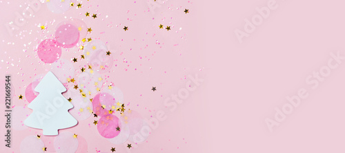 Christmas festive banner background: white christmas tree and confetti with sparcling glitter and stars.