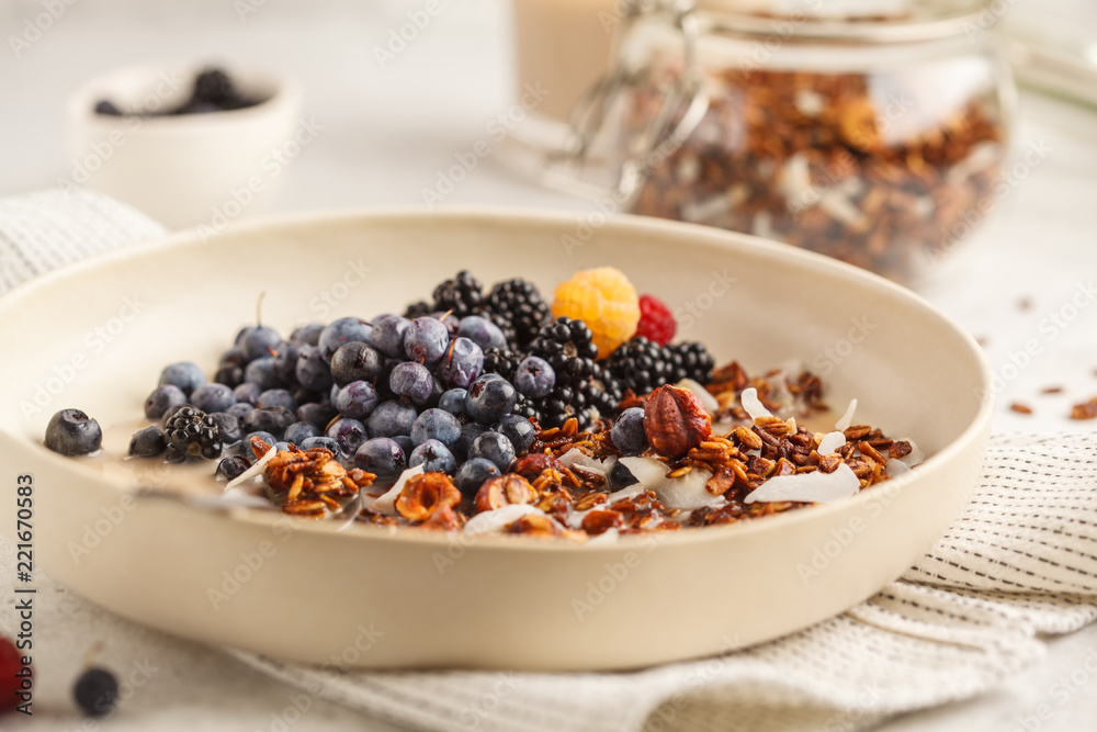 Homemade granola with nuts and coconut with berries and milk in a white plate. Homemade granola with nuts and coconut with berries and milk in a white plate.