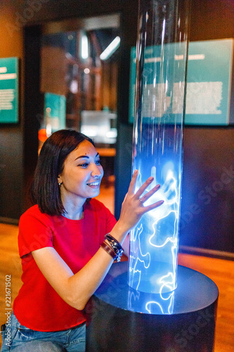  Woman visitor looking at Colorful plasma lamp experiment in physics museum