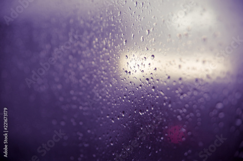 Raindrop on glass window, violet.