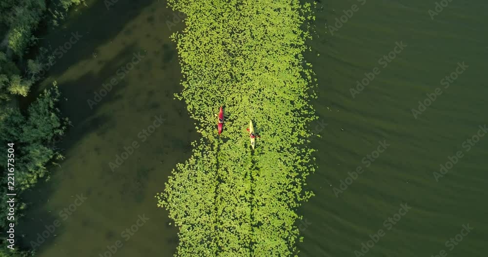 Two kayaks are sailing along a scenic river. Aerial view. Two kayaks are sailing along a scenic river. Aerial view.