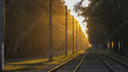 Railroad tracks without a train in the rays of sunset.