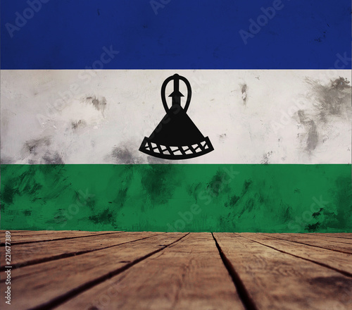 The floor of planks and plastered wall with a painted the Kingdom of Lesotho flag. 