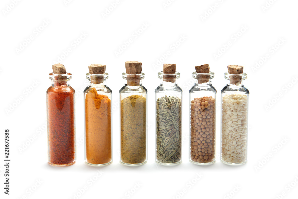 Row of small glass bottles with different spices on white background Row of small glass bottles with different spices on white background