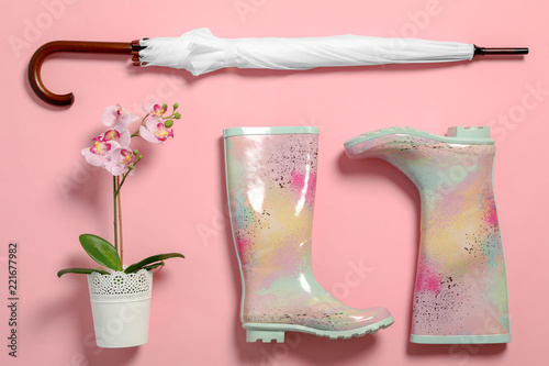 Fototapeta Naklejka Na Ścianę i Meble -  Flat lay composition with umbrella and rubber boots on color background