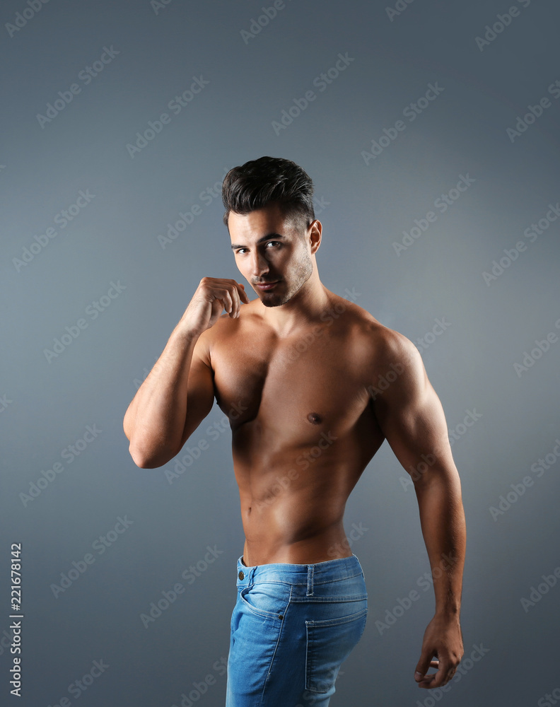 Fototapeta premium Shirtless young man in stylish jeans on grey background