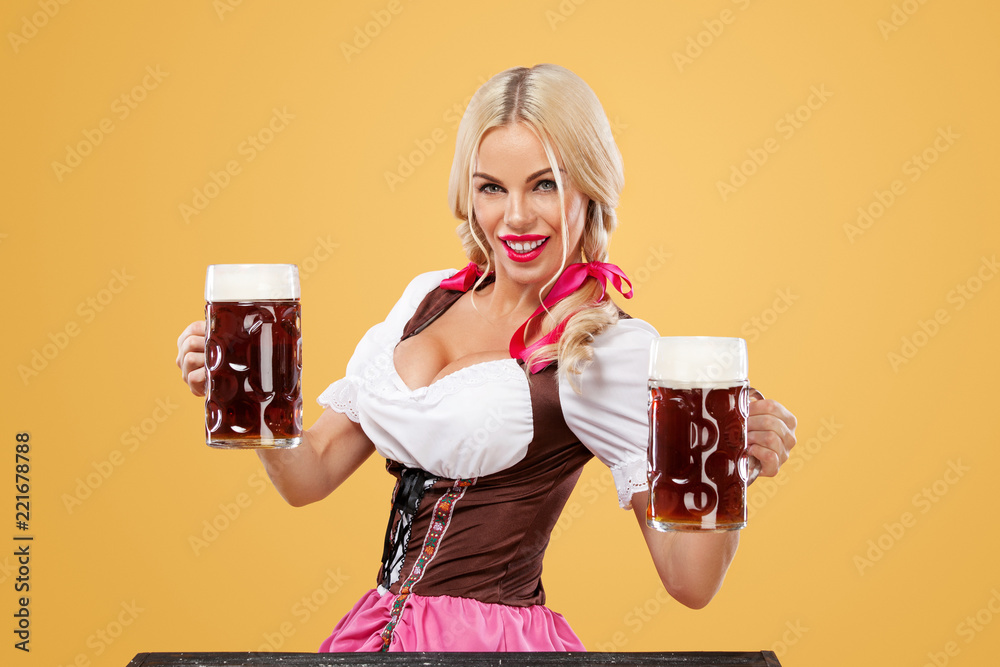 Oktoberfest beer fest. Young sexy girl - waitress, wearing a traditional  Bavarian dress, serving big mugs on orange background. Stock Photo | Adobe  Stock