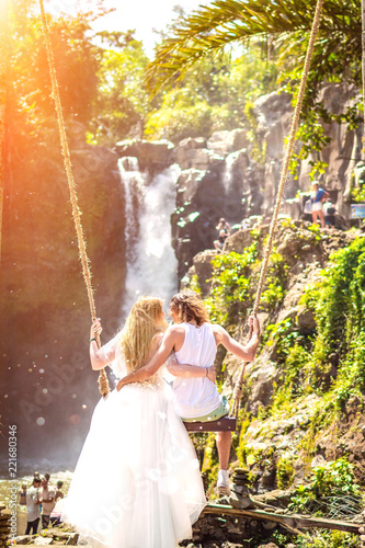 Young honeymoon couple swings in the jungle near the lake  Bali island  Indonesia.