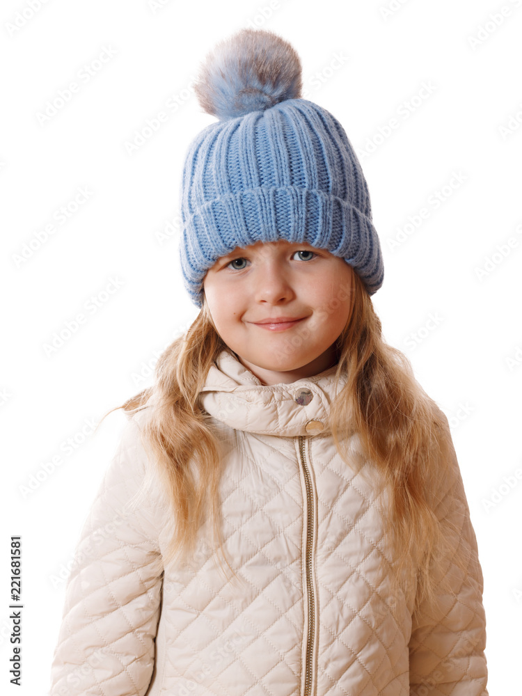 Little girl in blue knitted cap with fur pompon and beige jacket.Isolated on white background Little girl in blue knitted cap with fur pompon and beige jacket.Isolated on white background