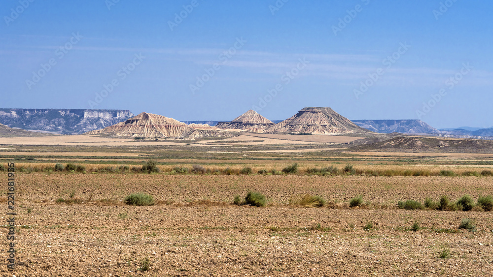 Spain, Bardenas Reales: Panorama view of famous Spanish natural semi desert sierra natural preserve park with Pisquerra rocky mountain chain, wide plains and blue sky - concept travel nature badlands