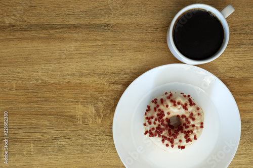 Donut with black coffee on wooden