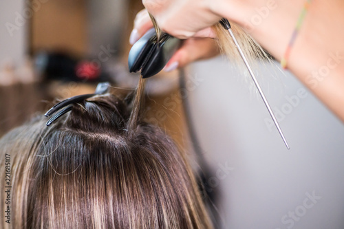 The hairdresser pulls the client hair, after washing his head, applying nutrients to the hair and drying the hair with a hair dryer, botox hair, restoring and nourishing the hair