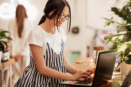Εκτύπωση καμβά A pretty slim dark-haired girl with glasses,wearing casual style, types somethin