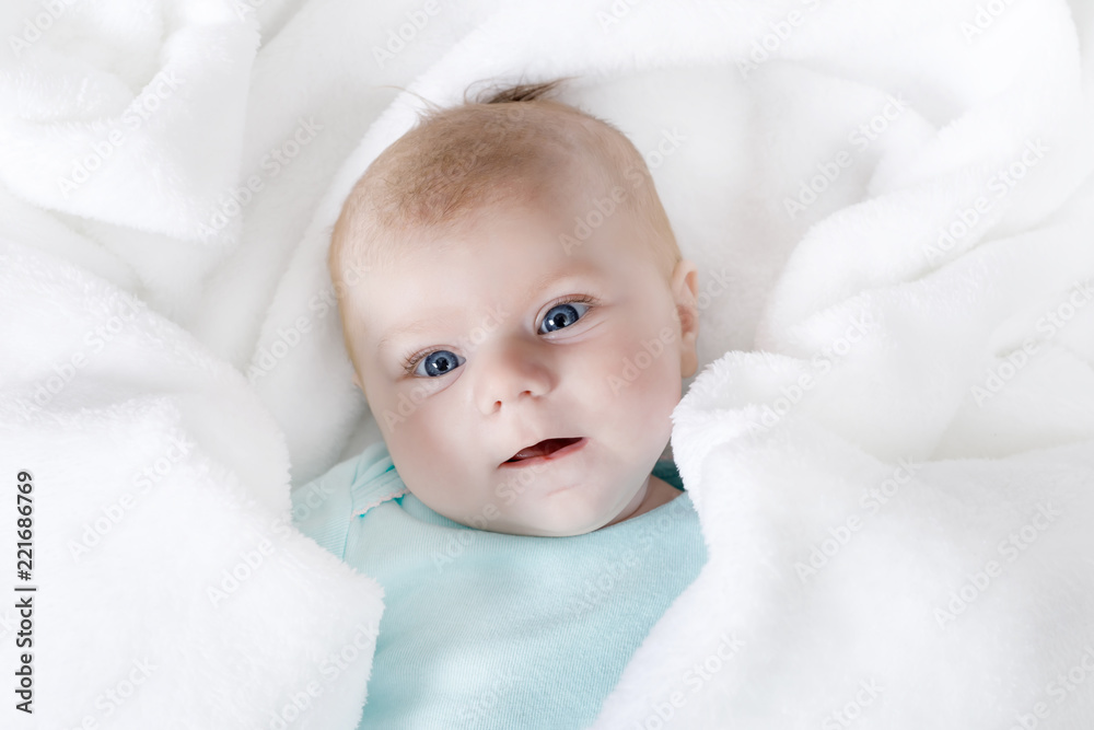 Cute adorable newborn baby in white bed and wrapped in blanket. New born child, little girl looking surprised at the camera. Family, new life, childhood, beginning concept Cute adorable newborn baby in white bed and wrapped in blanket. New born child, little girl looking surprised at the camera. Family, new life, childhood, beginning concept