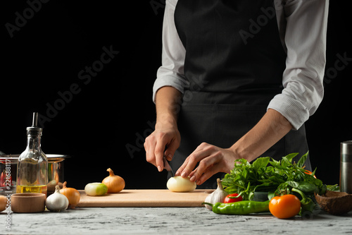 Preparation of tomato sauce by the hands of the chef, steps the process in the kitchen on a black background copy the text of the recipe.The concept of cooking food