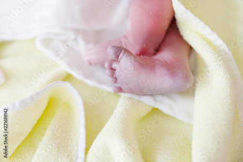 Newborn child seconds and minutes after birth. Cute tiny new born baby girl on towel. New life, beginning, healthcare