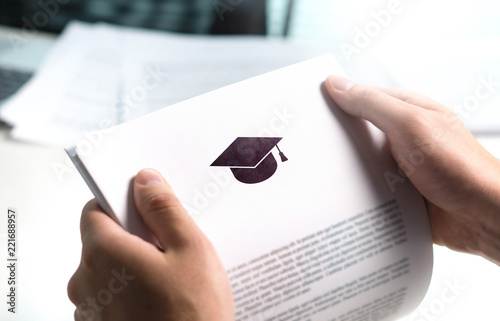 College or university application or letter from school. Student or teacher reading education document. Young man holding grant, graduation, study loan or scholarship paper. photo