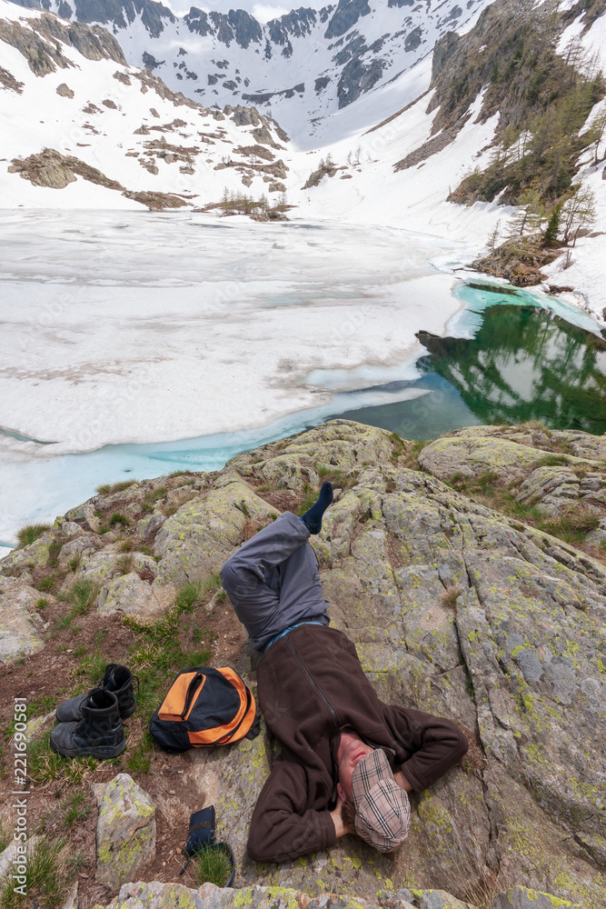 Un homme se repose au bord d'un lac gelé