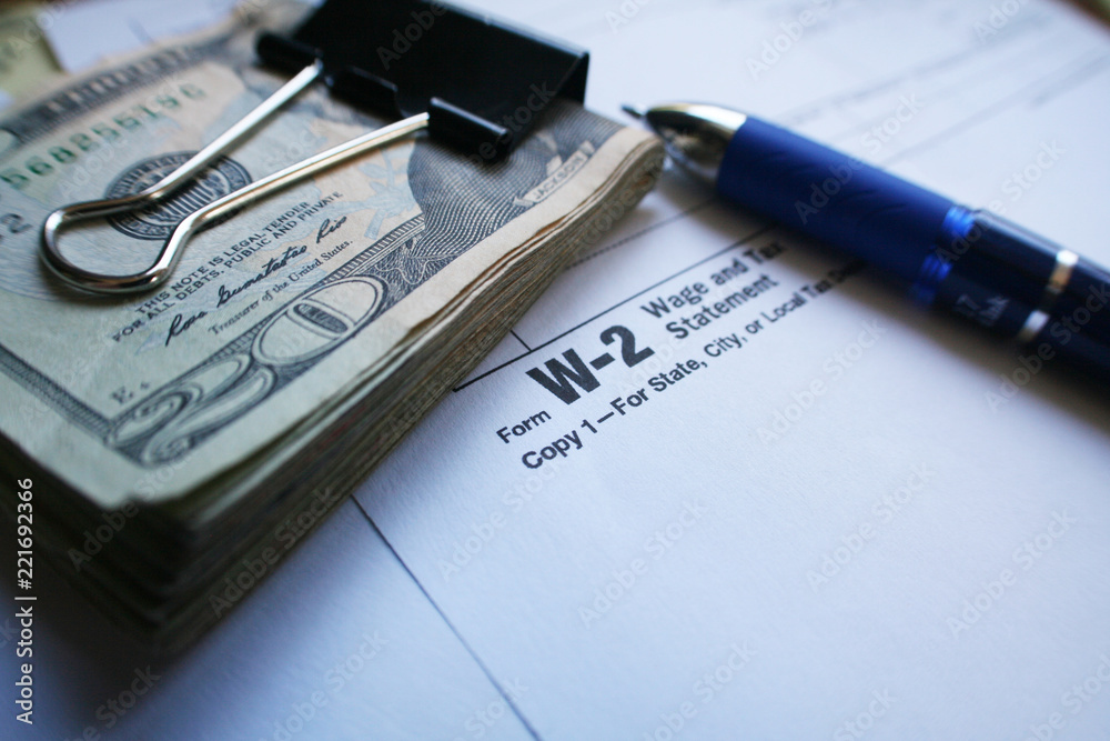 W-2 Tax form with Twenty Dollar Bills & Pen W-2 Tax form with Twenty Dollar Bills & Pen