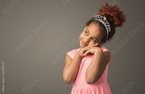 Little black girl dreaming, wearing tiara photo