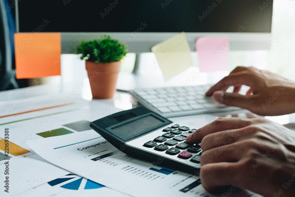 Businessman with calculator counting making notes at office hand is writes in a notebook