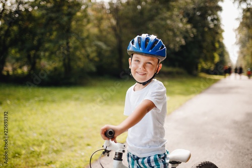 Little boy in helmet learning to ride bicycle park having fun