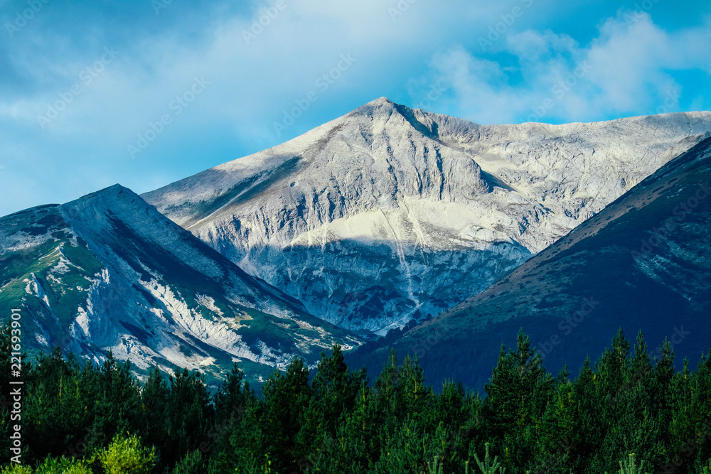 Beautiful alpine high mountains peaks, blue sky background. Amazing Mountain hiking paradise landscape, summertime.