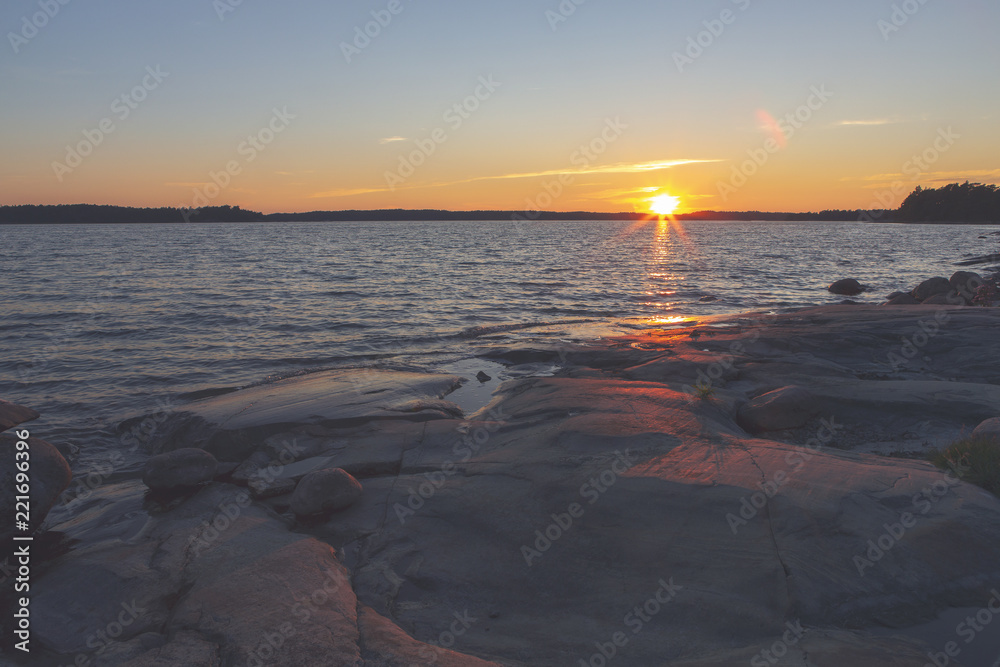 Sunset at the Finnish archipelago. Coastline at the sea. Image has a flare and vintage effect applied.