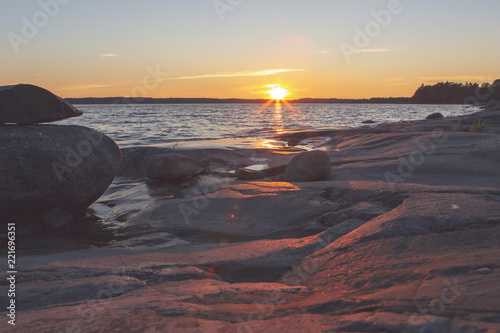 Sunset at the Finnish archipelago. Coastline at the sea. Image has a flare and vintage effect applied.