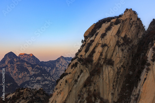Huashan, Mount Hua - Huayin, near Xi'an in Shaanxi Province China. Cliff Scenery with Steep Vertical Drop-off, Famous yellow granite mountains of China. Layers of Mountains in the distance, exotic