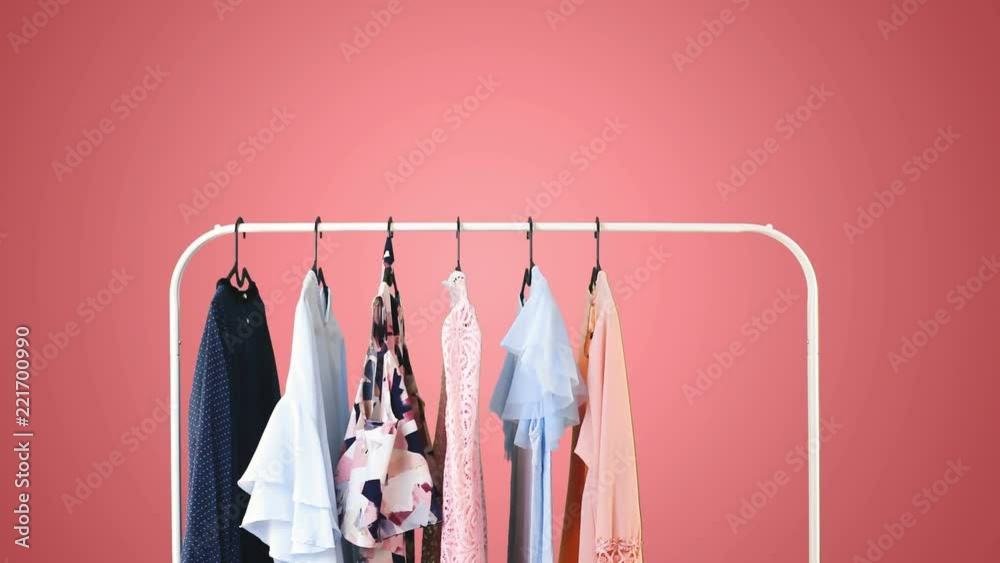 Women's clothing on a white clothes hanger on pink pastel background.