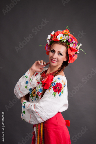 Cute young woman in a national Ukrainian suit. Portrait of a woman in a wreath of flowers