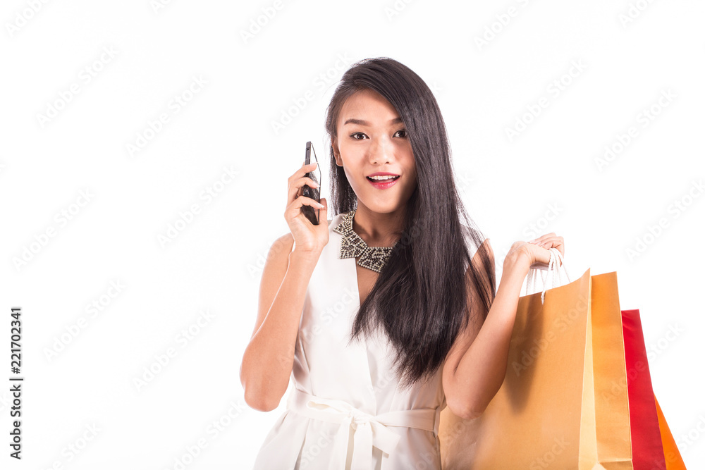 Beautiful Attractive Asian young woman talking in smartphone and holding shopping bags in her hand feeling so happiness and cheerful,Isolated on white background Beautiful Attractive Asian young woman talking in smartphone and holding shopping bags in her hand feeling so happiness and cheerful,Isolated on white background