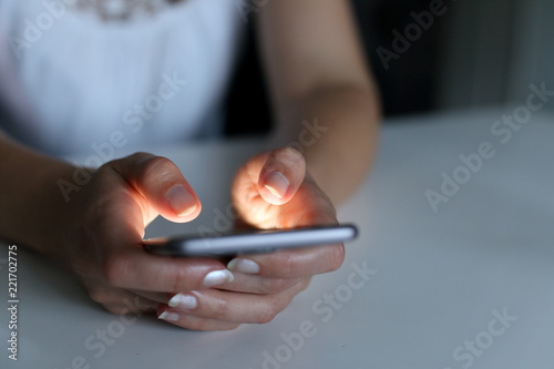 Frau tippt nachts auf Smartphone photo