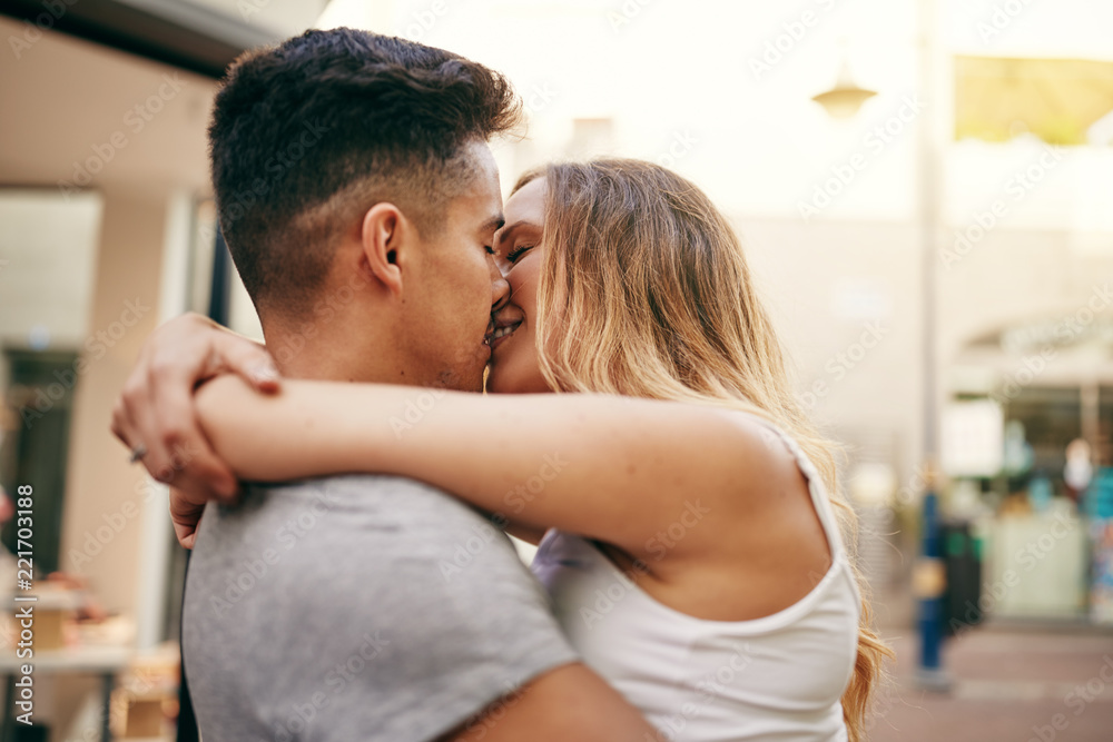 Affectionate young couple kissing each other in the city